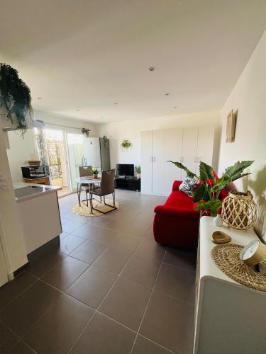 un salon avec un canapé rouge et une cuisine dans l'établissement Le Chic Azuréen, à Villeneuve-Loubet