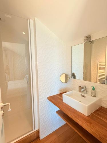a bathroom with a white sink and a shower at Le Chantier d 'Ernest- Loft T4 les pieds dans l' eau in Carantec