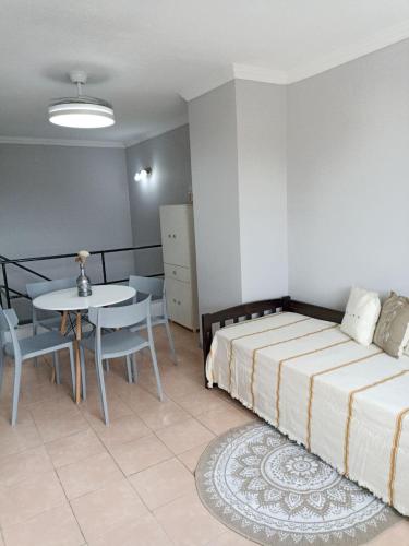 Un dormitorio con una cama y una mesa y un comedor. en Departamento Momó, en San Miguel de Tucumán