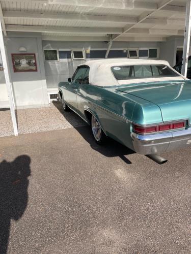 a green and white car parked in a garage at Fleninge Classic Motel in Fleninge