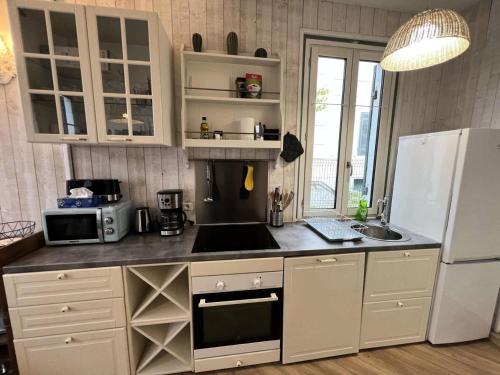 une cuisine avec un réfrigérateur blanc et un évier dans l'établissement Résidence 155-soulac Sur Mer - 155 - Charmant appartement cosy avec jardin en plein cœur de Soulac-sur-Mer MAE-2533, à Soulac-sur-Mer
