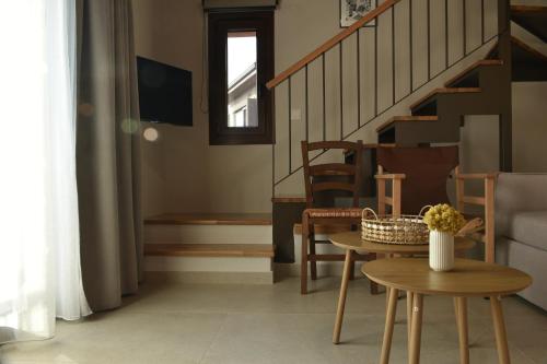 a living room with a table and a staircase at Stone Hut Apartments in Ayios Nikolaos Sithonia