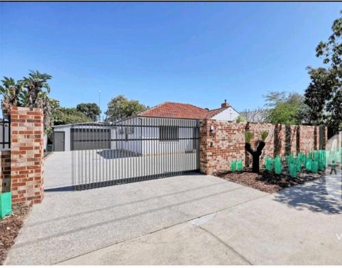 a fence in front of a house with a gate at Heart of Lathlain in Perth