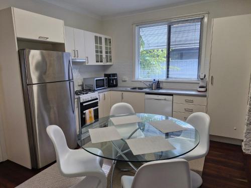 a kitchen with a glass table and white appliances at Heart of Lathlain in Perth