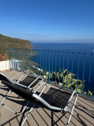 a chair sitting on a balcony overlooking the ocean at Villa Vista Mare a Filicudi in Filicudi