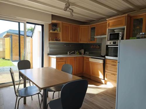 une cuisine avec une table, des chaises et un réfrigérateur dans l'établissement Résidence Loc-78-la Baule Escoublac - LA BAULE - CHARMANTE MAISON MAE-2563, à La Baule