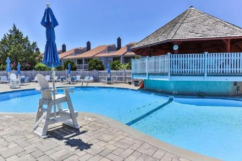 a swimming pool with a chair and an umbrella at Spacious Oceanfront 3BR Condo with Private Beach in Ideal Hyannis Location in Barnstable