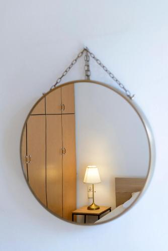 a large circular mirror with a table and a lamp at AGALI 2 Superior Mezonet front of the sea in Akrogiali