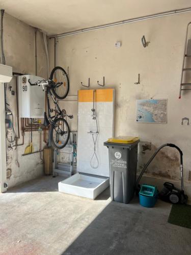 un garage avec un vélo suspendu au mur dans l'établissement Les Magnolias, à Les Sables-dʼOlonne