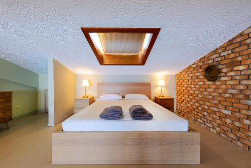 a bedroom with a bed and a brick wall at AGALI 2 Superior Mezonet front of the sea in Akrogiali