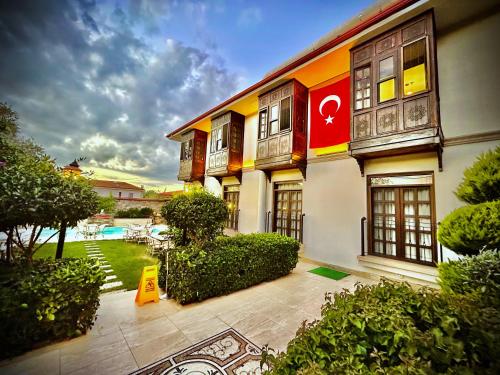 a building with a flag on the side of it at Livia Garden Hotel in Selcuk