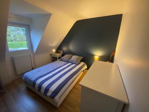 une petite chambre avec un lit et une fenêtre dans l'établissement Family home, à Saint-Malo