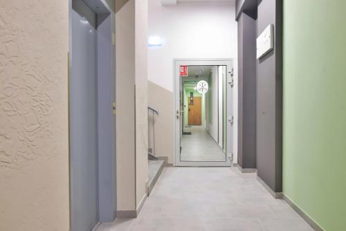 a hallway with white walls and a tile floor at TINTURA by BAST - Wanna, Antresola, OFF Piotrkowska, EC1 ,Stajnia Jednorożca, Winda, Parking na Terenie, Orientarium, Hopa Lupa, ATLAS ARENA in Łódź