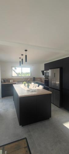 a large kitchen with a large island in the middle at Ti vakansin war aod an emrodez in Ruca