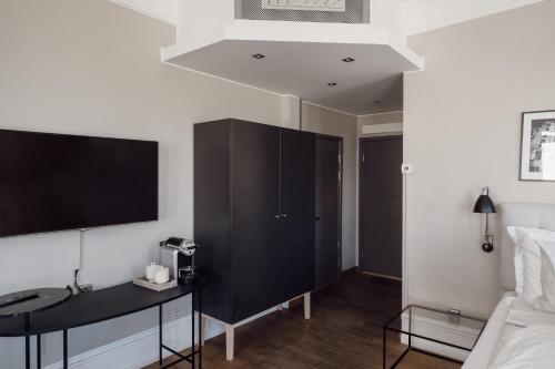 a bedroom with a black cabinet and a tv on the wall at TwentySix in Malmö