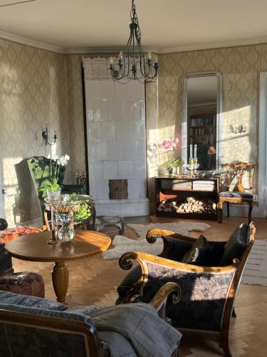 a living room with couches and a table and a fireplace at Norrgården Hälsingland in Vallsta