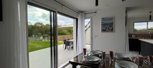 a kitchen with a table and a large glass door at Ti vakansin war aod an emrodez in Ruca