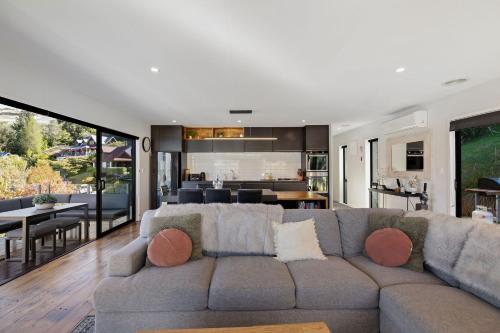 a living room with a couch and a dining room at Viscount Haven - Lake Views in Queenstown