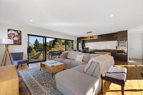 a living room with a couch and a kitchen at Viscount Haven - Lake Views in Queenstown