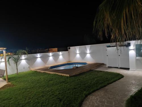 a backyard with a swimming pool on a wall at night at Villa Madame in Monacizzo