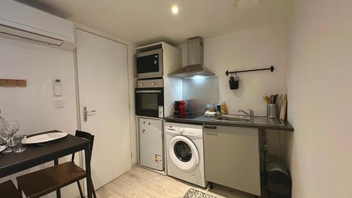 une petite cuisine avec une machine à laver et un évier dans l'établissement Brise de Loire, à Nevers
