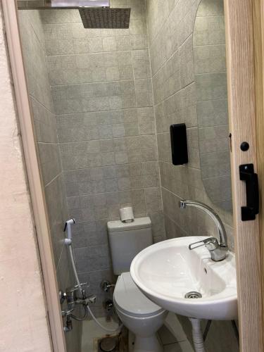 a bathroom with a white toilet and a sink at Alex Rooms in Alexandria