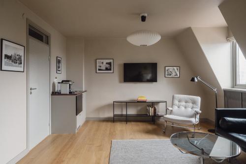 a living room with a chair a table and a tv at TwentySix in Malmö