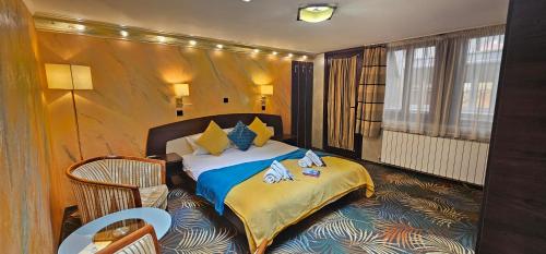 a hotel room with a bed and a chair at La Dolce Vita in Braşov