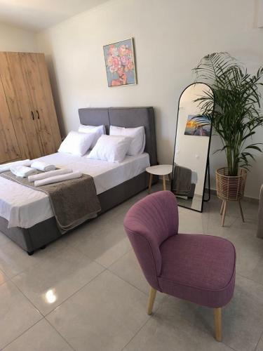 a bedroom with a large bed and a chair at Araucaria studio Manis in Mesochórion