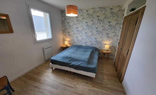 une chambre avec un lit bleu et une fenêtre dans l'établissement A 900 mètres de la plage de Kerhillio Maison lumineuse pour 6 personnes, à Erdeven