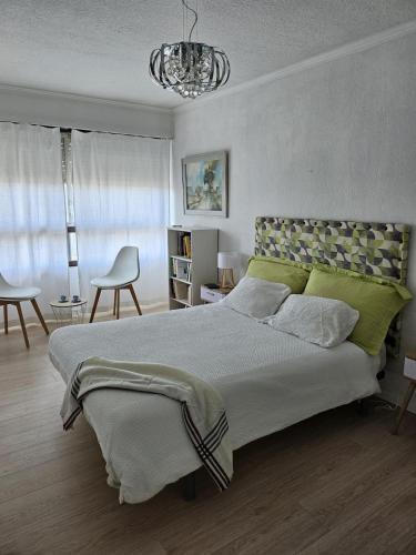 une chambre avec un grand lit et un lustre dans l'établissement Appartement au centre de Bordeaux, à Bordeaux