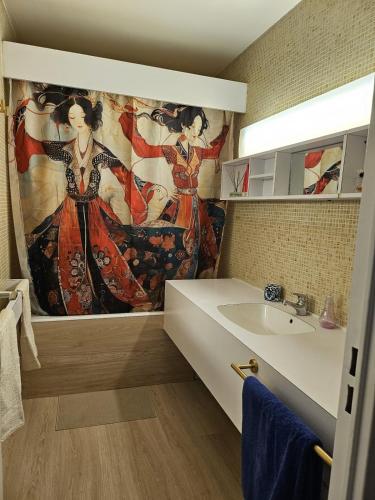 La salle de bains est pourvue d'une peinture murale à côté d'un lavabo. dans l'établissement Appartement au centre de Bordeaux, à Bordeaux