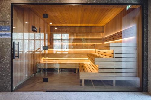a glass door of a building with a bench inside at Albatross 949 by the Sea in Ķesterciems
