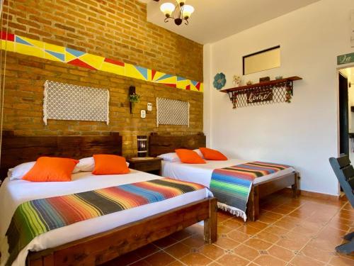 a room with two beds and a brick wall at Mamatina Hotel in Santa Rosa de Cabal
