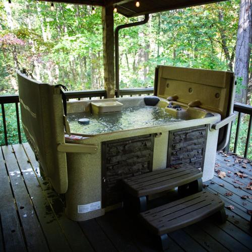 an outdoor kitchen with a bench on a deck at Aspen - by The Chalets in Logan