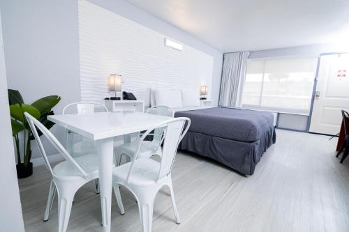a hotel room with a bed and a table and chairs at Disney 12 minutes for family, Pool and parking FREE in Kissimmee