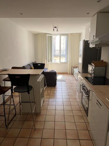 une cuisine avec une table et un comptoir dans l'établissement Appartement rénové à 5min de la Comédie - Clim - 4 personnes, à Montpellier