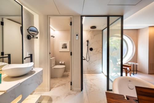 a bathroom with a tub and a sink and a shower at Hotel Unique in Sao Paulo