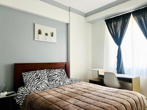 a bedroom with a bed and a desk and a window at Flat en Av Granados in Quito