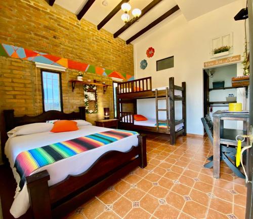 a bedroom with a bed and two bunk beds at Mamatina Hotel in Santa Rosa de Cabal