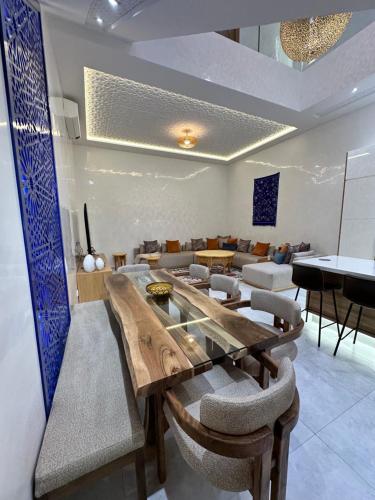 ein Esszimmer mit einem großen Holztisch und Stühlen in der Unterkunft Riad De Luxe Marrakech in Marrakesch