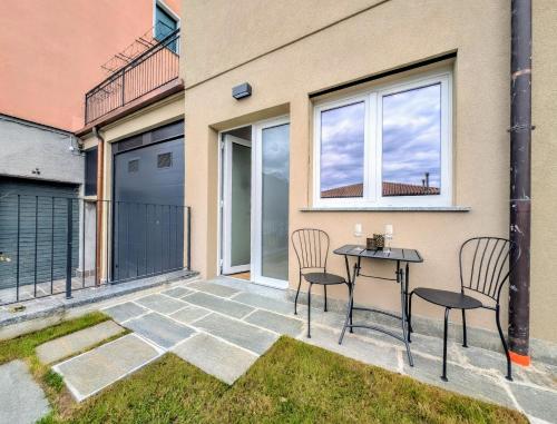 a patio with two chairs and a table in front of a building at Appartamento Le Rondini B in Pianello Del Lario