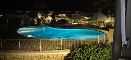 Una vista aérea de una piscina por la noche. en Appartement F2 Vue Piscine, en Saint-François