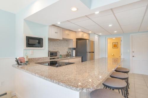 a kitchen with a counter and some stools in it at Patio and Pond View Serene Cape Cod Escape in Mashpee
