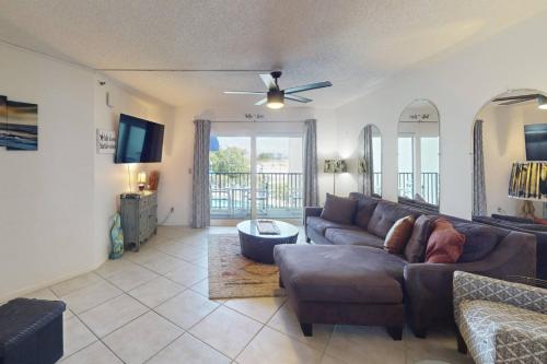 a living room with a couch and a ceiling fan at 105 - Caprice Resort in St. Pete Beach