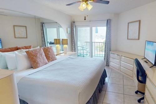 a bedroom with a bed and a desk and a television at 105 - Caprice Resort in St. Pete Beach