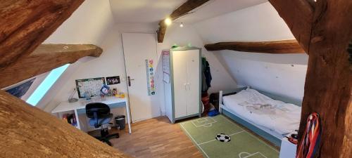 une petite chambre avec un lit et un bureau dans l'établissement Country house for animals and nature lovers, à Courcy-aux-Loges