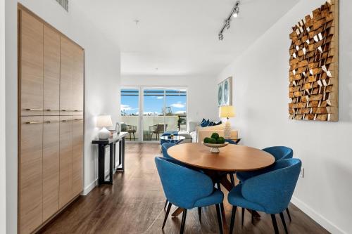 a dining room with a table and blue chairs at Luxury Penthouse 2-BR - with Pool & Gym Access in Los Angeles