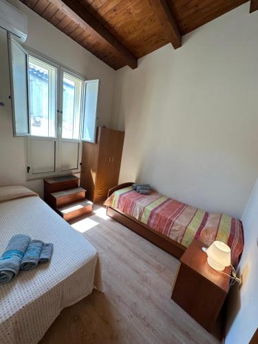 a bedroom with two beds and a table and a window at Affaccio sul Mare Attico in Tropea