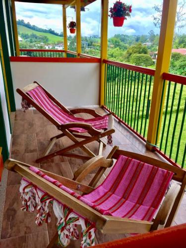 two rocking chairs sitting on a balcony with a view at Mamatina Hotel in Santa Rosa de Cabal